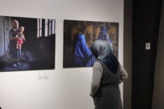 Sanat sergisi görünen kadın izleyici, çerçevede portre ve yüz detaylarıyla fotoğraflar.